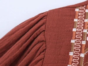 Detailed macro view of retro brick red cotton linen fabric with geometric embroidery trim
