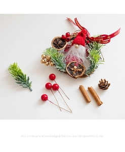 Detailed view of Christmas wreath with Santa plush, pine needles, and red berries decor