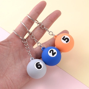 Creative billiard ball keychains in grey, blue, and orange with metal rings held in hand