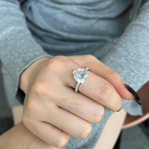 Close-up of S925 silver ring featuring a large pink heart-shaped zircon on a model's hand