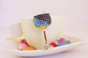 Detailed view of a gold-plated wine glass keychain encrusted with blue and white crystals