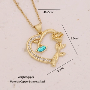 Detailed view of gold heart pendant with rose engraving and blue opal inlay features