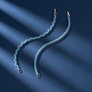 Detail of silver tennis chain with double row blue and turquoise stones on a dark background
