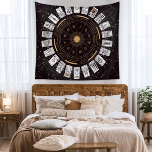 Detail of bohemian astrology wall tapestry with gold zodiac signs and tarot motifs