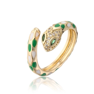 Close-up of golden snake ring with green enamel spots and sparkling micro-pave diamonds
