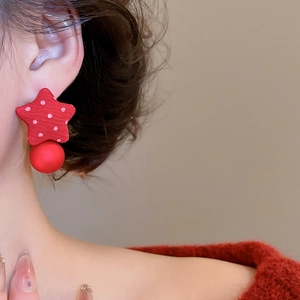 Detailed shot of red polka dot star earrings with fabric texture and matte sphere