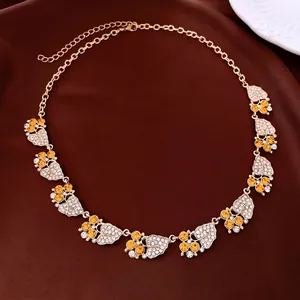 Vintage leaf pendant necklace with amber and white zircons on a dark silk fabric