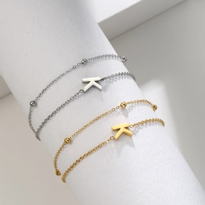 Detail of silver and gold stainless steel bracelets with letter K pendant and beads