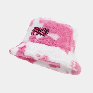 Detailansicht eines modischen Fischerhuts aus Plüsch mit rosa Kuhmuster und #FOMO-Patch