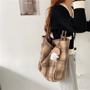 Brown plaid wool tote bag detail with fish plush charm and large capacity on model