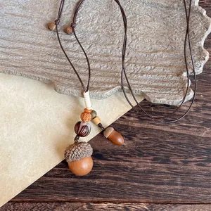 Detail of handmade ethnic necklace featuring acorn pendant and adjustable cord