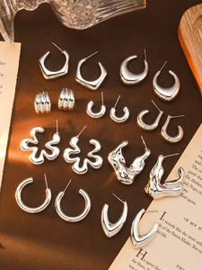 Macro view of silver geometric flower earrings on vintage book page background