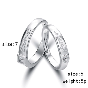 Detail of silver couple rings with 'Love you forever' engraving and square stones