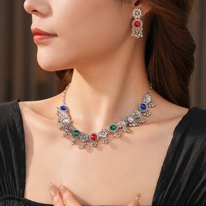 Detail of vintage silver necklace set with multi-color stones and bell charms on model