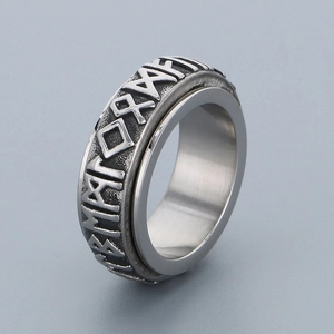 Macro detail of silver spinner ring featuring embossed vintage Viking runes on steel