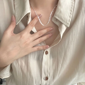 Minimalist S925 sterling silver chain necklace worn by a model on a beige shirt