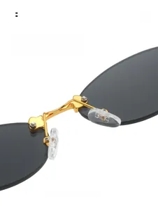 Detail of adjustable silicone nose pads and gold metal bridge on oval rimless sunglasses