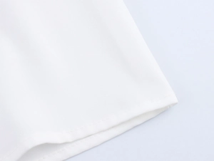 Detail of white blouse showing double-needle hem stitching and fine plain weave texture