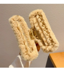 Detail of large beige plush hair claw clip with strong metal spring and soft faux fur