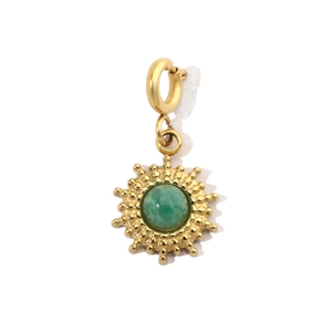 Detailed shot of a gold sunburst pendant featuring a vibrant green gemstone center