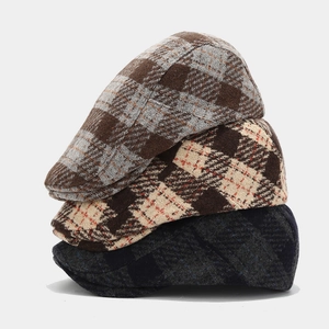 Classic vintage plaid beret hats in stacked arrangement for winter fashion accessories