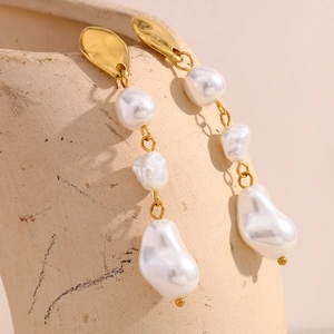 Detail showing three baroque pearls on a gold-plated stainless steel drop earring