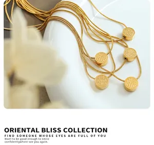 Detail of gold snake chain with sliding Fu and Xi character pendant on porcelain