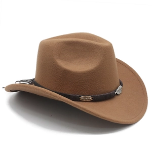 Macro shot of vintage metal feather pendant and leather band on a brown western felt hat