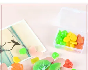 Macro shot of assorted PVC miniature fruit slices with a clear plastic storage container