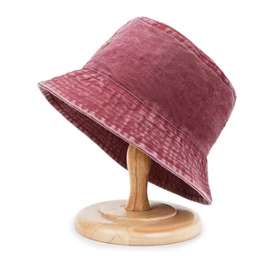Vintage washed red canvas bucket hat for sun protection shown on a wooden stand