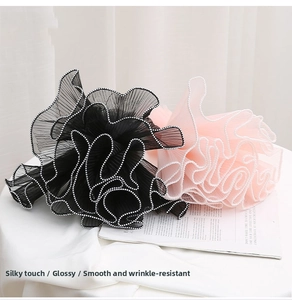 Macro view of pleated mesh flower wrapping material with elegant white pearl trim detail