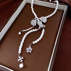 Vintage long tassel pearl necklace with silver bird pendant and metallic flower details