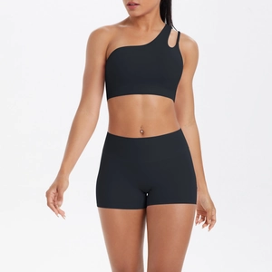 Detail of black one-shoulder yoga set showing asymmetric cutout bra and high-waist shorts