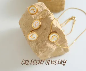 Detailed shot of titanium moon necklace and earrings with mother of pearl inlay on stone
