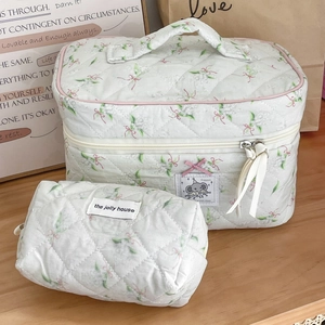 Quilted floral makeup bag set with green leaf patterns and cute pink bows on a desk