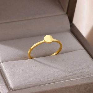 Minimalist gold-plated stainless steel ring with a geometric round plate on a jewelry box