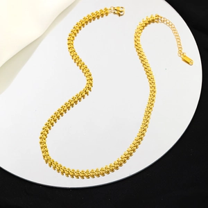 Minimalist gold wheat chain necklace in stainless steel displayed on a mirror surface