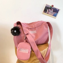 Borsa tote rosa con tracolla regolabile e accessorio decorativo con etichetta
