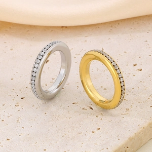 Macro detail of gold and silver rings set with sparkling clear zircons on side