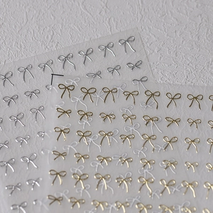 Minimalist black line bow nail art stickers with gold and silver metallic patterns