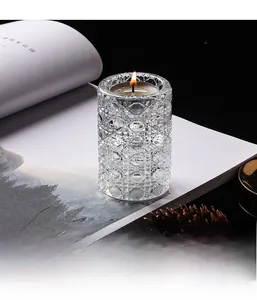 Detail of crystal glass candle holder with geometric cut texture and lit tealight