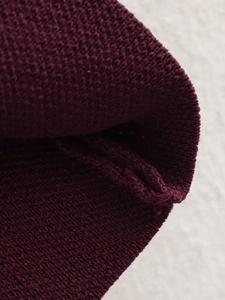 Detaillierte Makroansicht des weinroten Strick-Cardigans mit hochwertiger Textur