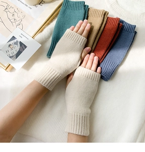 Macro view of multi-color knitted fingerless gloves showing wool texture and warm beige shade