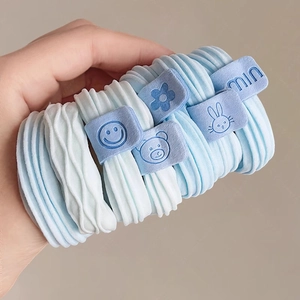 Blue elastic hair ties set with cartoon charms and ribbed texture held in hand