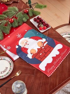 Close-up of linen table runner featuring Santa Claus and Happy Holidays Season greeting