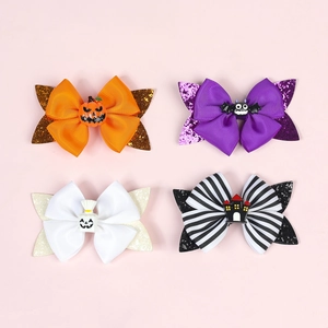 Detail of four Halloween hair clips with glitter bows and resin figures on pink background