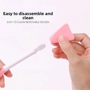 Close-up of dual-ended facial cleansing tool with removable pink sponge and easy clean design