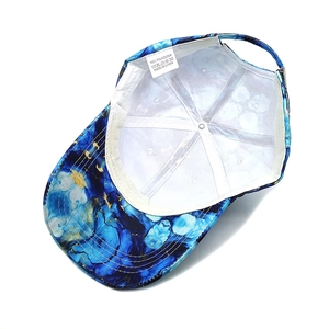 Tie-dye baseball cap with blue and gold marble pattern showing back view and inner lining