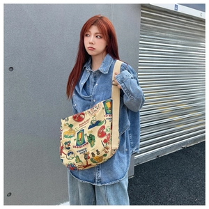 Detail view of canvas crossbody bag featuring retro American vintage prints and beige strap