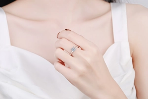 Detail showing the four-prong setting of a princess cut moissanite ring on a hand